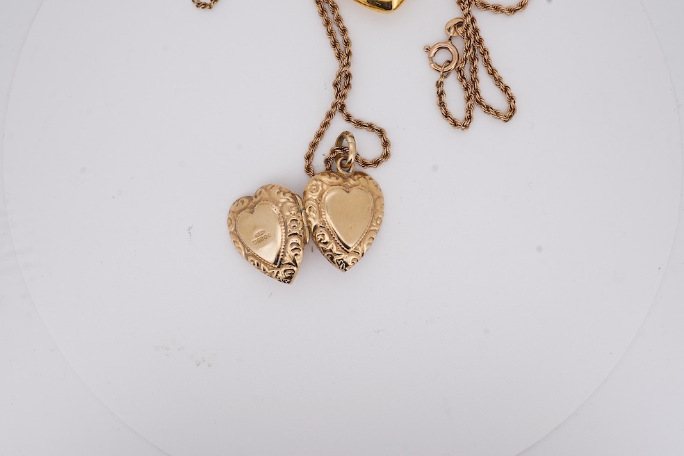 A modern embossed 9ct gold heart shaped locket, 21mm, on a similar 9ct gold rope twist chain, 46cm, together with one other yellow metal heart shaped locket, on a yellow metal chain, gross weight 14.5 grams. Condition -